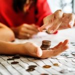 Coins getting stacked in palm of a hand