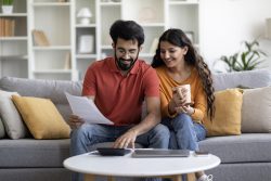 Married Couple Planning Budget Together, Reading Papers And Calculating Spends